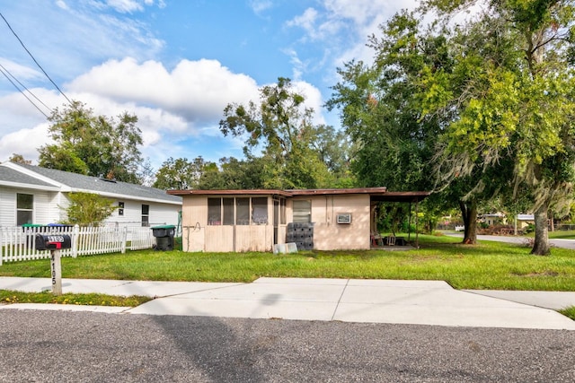 ranch-style house featuring a front lawn and a carport