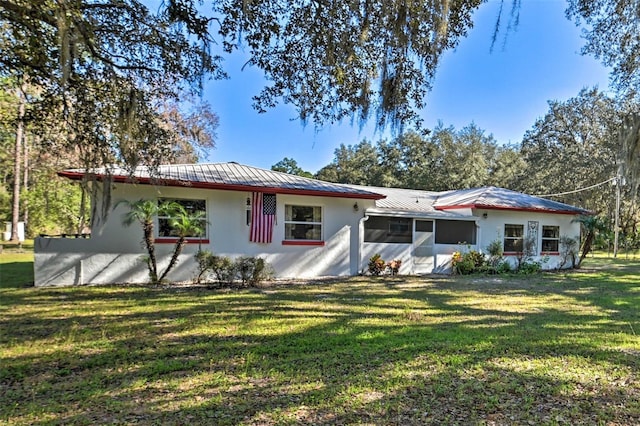 view of front of house featuring a sunroom and a front yard