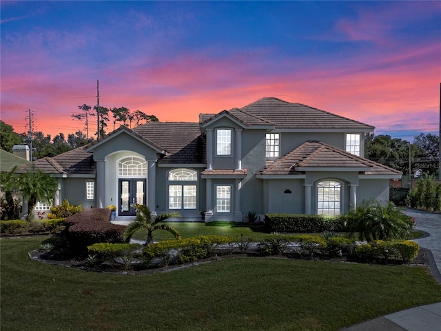 view of front facade featuring a lawn and french doors