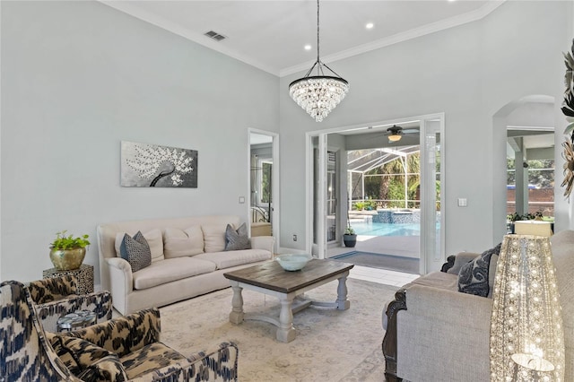 living room with a high ceiling, a notable chandelier, and ornamental molding