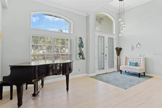 foyer entrance featuring french doors, ornamental molding, and a high ceiling