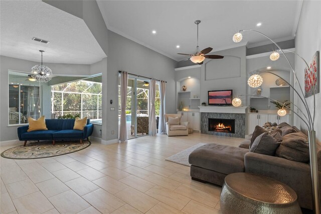 living room with ceiling fan, ornamental molding, and light tile patterned floors