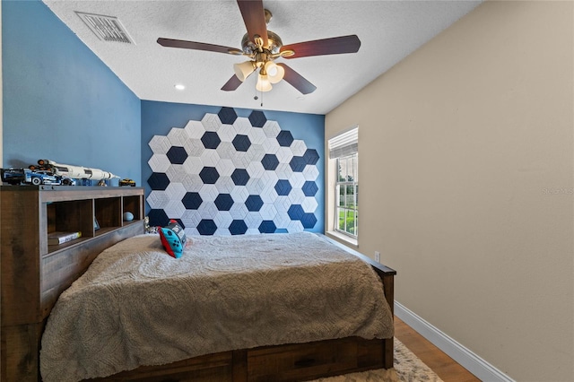 bedroom with ceiling fan, a textured ceiling, and hardwood / wood-style flooring