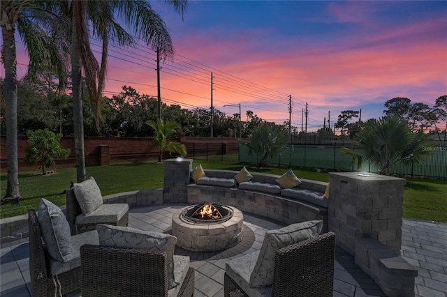 patio terrace at dusk with a lawn and an outdoor fire pit