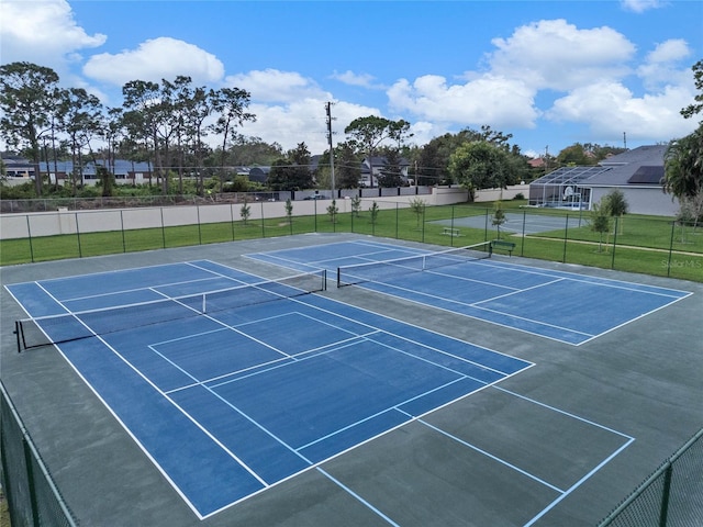 view of tennis court with a yard