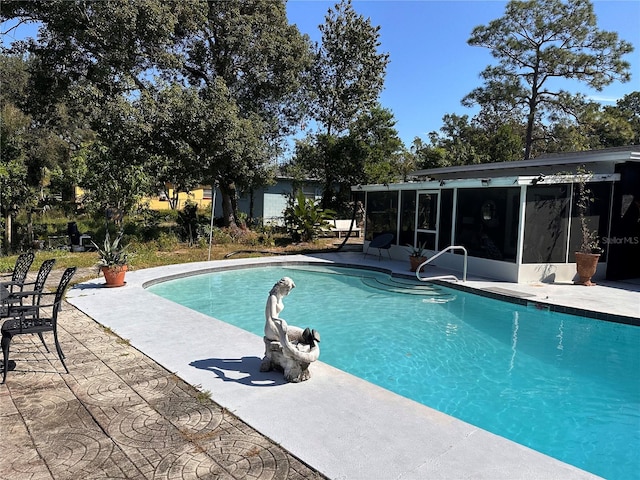 view of pool featuring a sunroom and a patio area