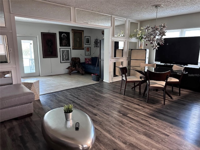 dining area featuring hardwood / wood-style flooring, a wealth of natural light, and a textured ceiling