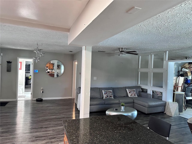 living room featuring ceiling fan, a textured ceiling, and dark hardwood / wood-style flooring