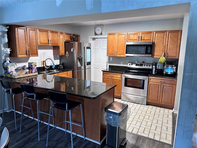 kitchen with stainless steel appliances, dark hardwood / wood-style floors, kitchen peninsula, and a breakfast bar area