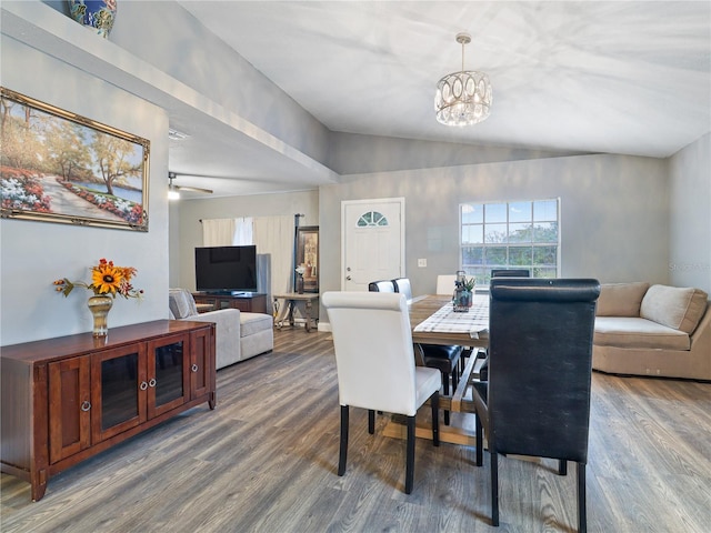 dining space featuring wood-type flooring, lofted ceiling, and a notable chandelier