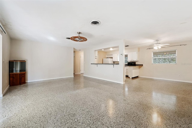 unfurnished living room with ceiling fan