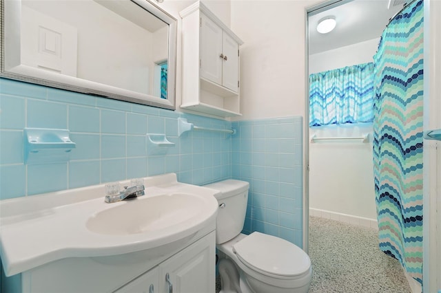 bathroom with tile walls, vanity, and toilet