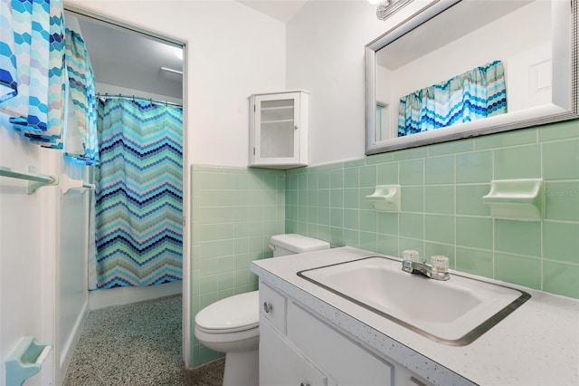 bathroom with walk in shower, vanity, toilet, and tile walls