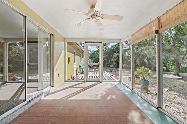 unfurnished sunroom featuring ceiling fan