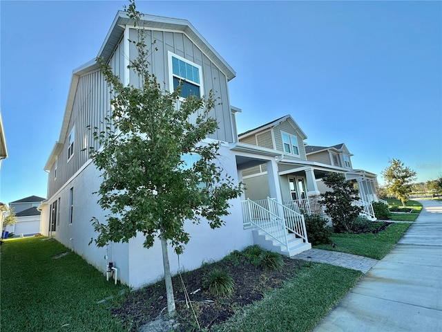 view of side of property with covered porch and a yard