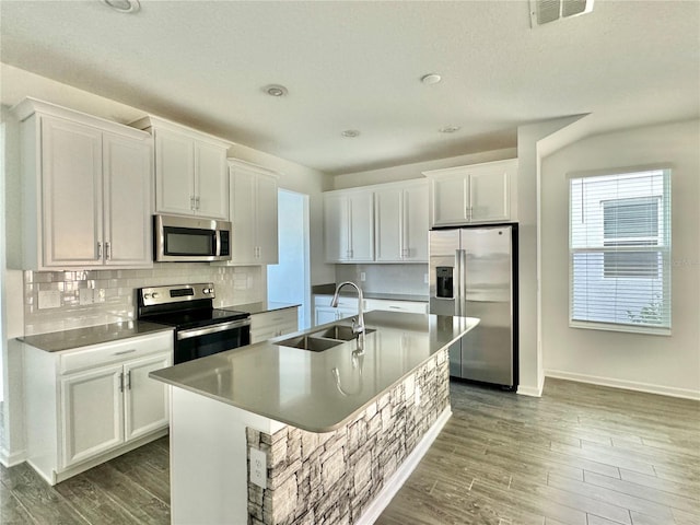 kitchen featuring sink, wood-type flooring, a center island with sink, white cabinets, and appliances with stainless steel finishes