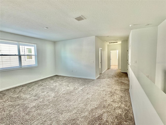 carpeted empty room featuring a textured ceiling