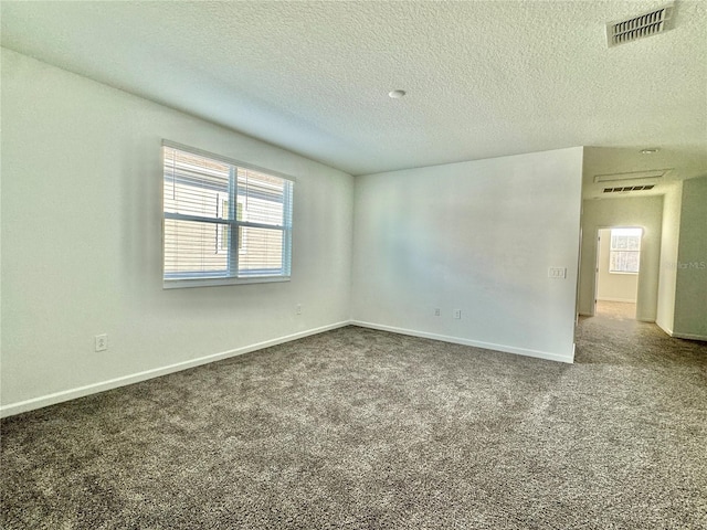 carpeted spare room featuring a textured ceiling