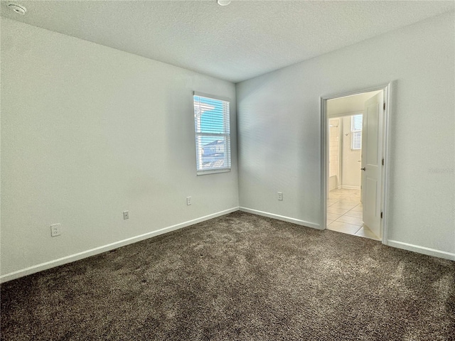 carpeted spare room with a textured ceiling