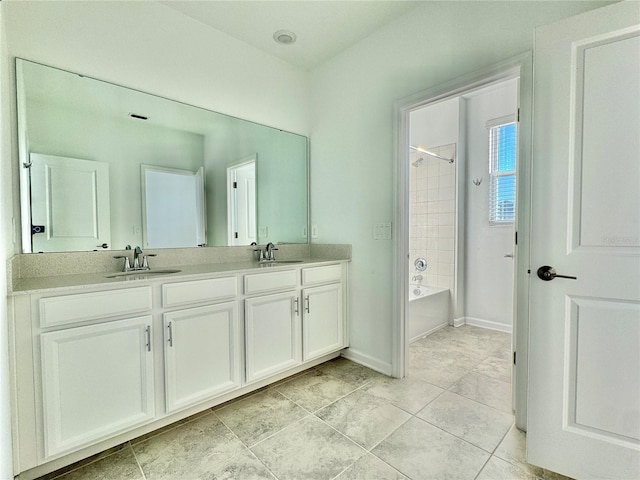 bathroom featuring tile patterned flooring, tiled shower / bath combo, and vanity