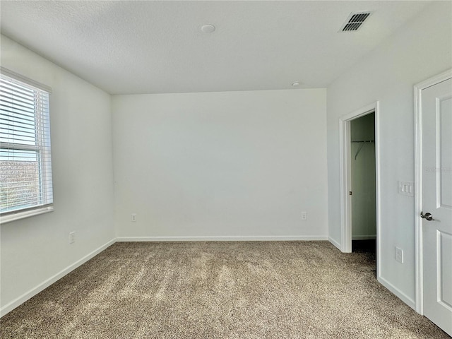 unfurnished bedroom with light colored carpet and a textured ceiling