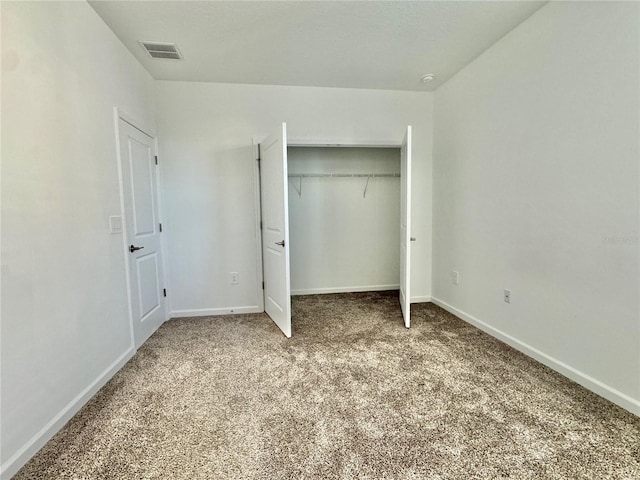 unfurnished bedroom with light carpet and a closet