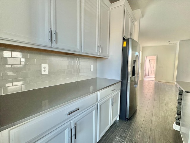 kitchen with white cabinets, decorative backsplash, stainless steel fridge with ice dispenser, and dark wood-type flooring