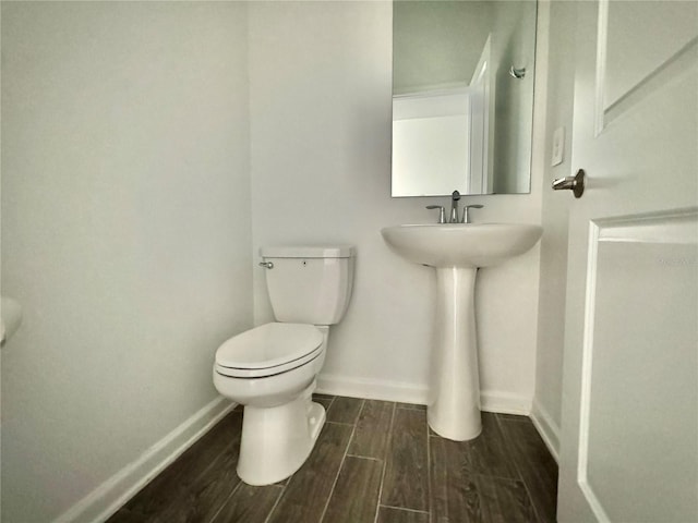 bathroom with hardwood / wood-style floors and toilet