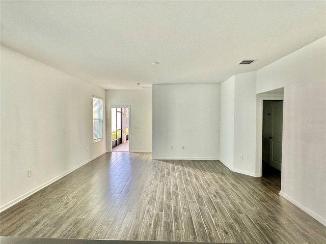 spare room with a textured ceiling and hardwood / wood-style flooring