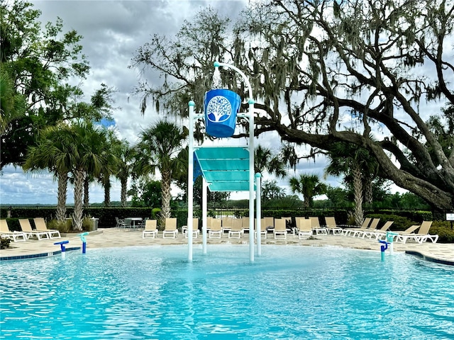 view of swimming pool with pool water feature and a patio area