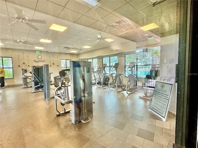 workout area with a paneled ceiling, plenty of natural light, and ceiling fan