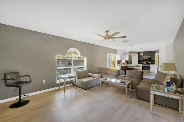 living room featuring light hardwood / wood-style floors and ceiling fan