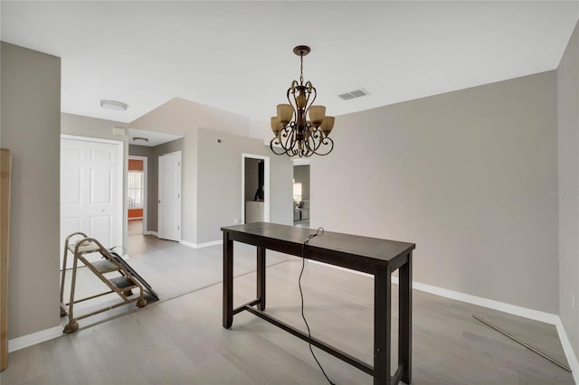 unfurnished dining area with an inviting chandelier and hardwood / wood-style flooring