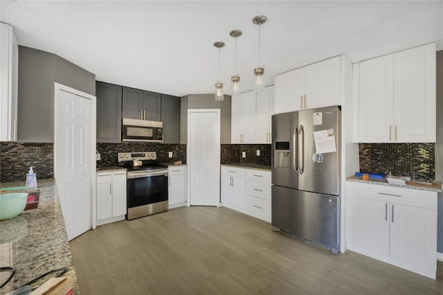 kitchen with pendant lighting, backsplash, light hardwood / wood-style flooring, appliances with stainless steel finishes, and white cabinetry