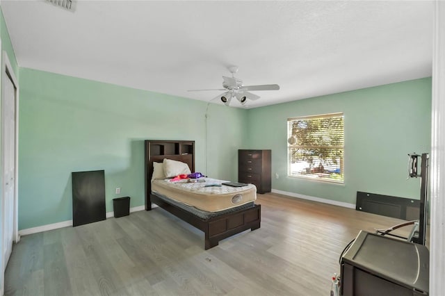 bedroom featuring ceiling fan, a closet, and light hardwood / wood-style flooring