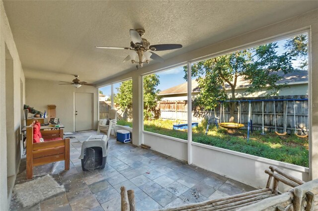 sunroom / solarium featuring ceiling fan