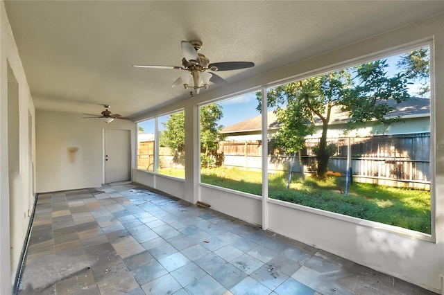 unfurnished sunroom with ceiling fan