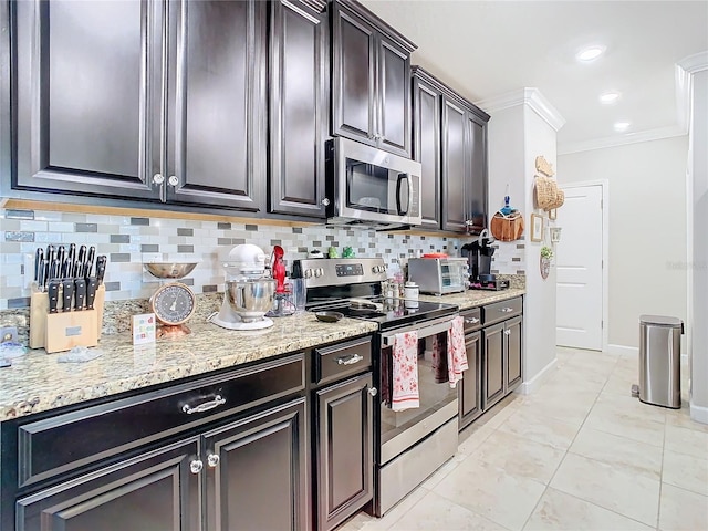 kitchen with light tile patterned floors, ornamental molding, appliances with stainless steel finishes, tasteful backsplash, and dark brown cabinetry