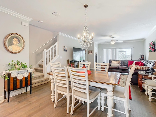 dining space featuring ceiling fan with notable chandelier, hardwood / wood-style flooring, and ornamental molding