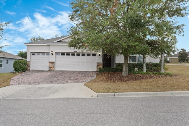 view of property hidden behind natural elements with a garage and a front lawn