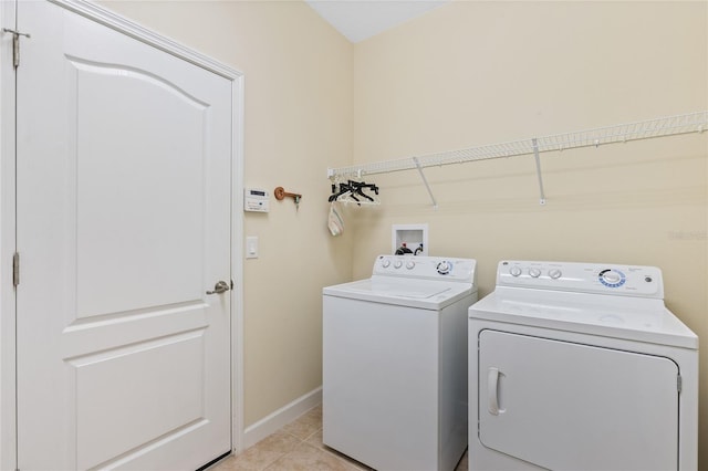 laundry room with separate washer and dryer and light tile patterned floors