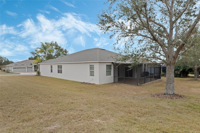 rear view of house with a yard, a sunroom, and a garage