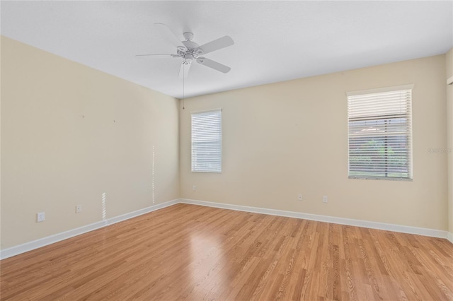 empty room with ceiling fan, a healthy amount of sunlight, and light hardwood / wood-style floors