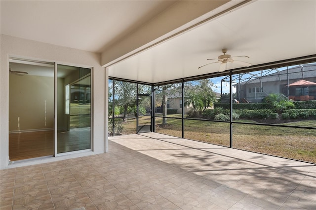 unfurnished sunroom featuring ceiling fan and a healthy amount of sunlight