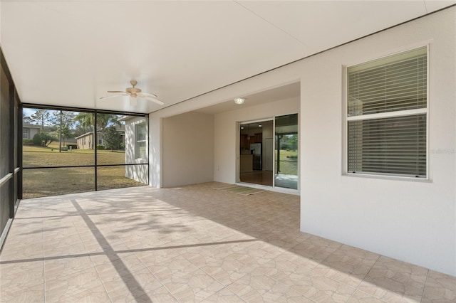 unfurnished sunroom featuring ceiling fan