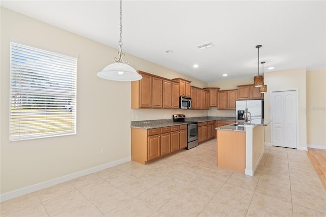 kitchen with sink, a center island with sink, appliances with stainless steel finishes, pendant lighting, and light stone countertops