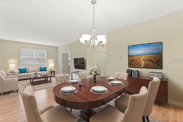 dining area with a notable chandelier and light wood-type flooring