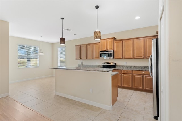 kitchen with stainless steel appliances, an island with sink, hanging light fixtures, and light tile patterned floors