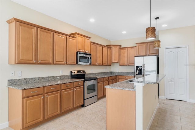 kitchen featuring sink, light stone counters, hanging light fixtures, a center island with sink, and appliances with stainless steel finishes