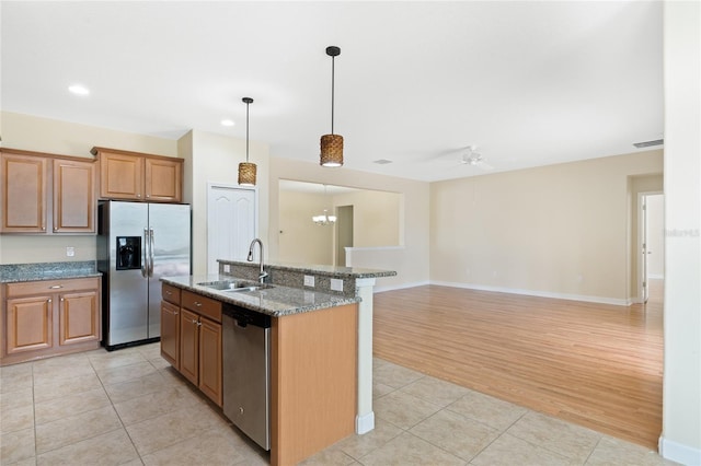 kitchen with appliances with stainless steel finishes, sink, a center island with sink, and light tile patterned floors